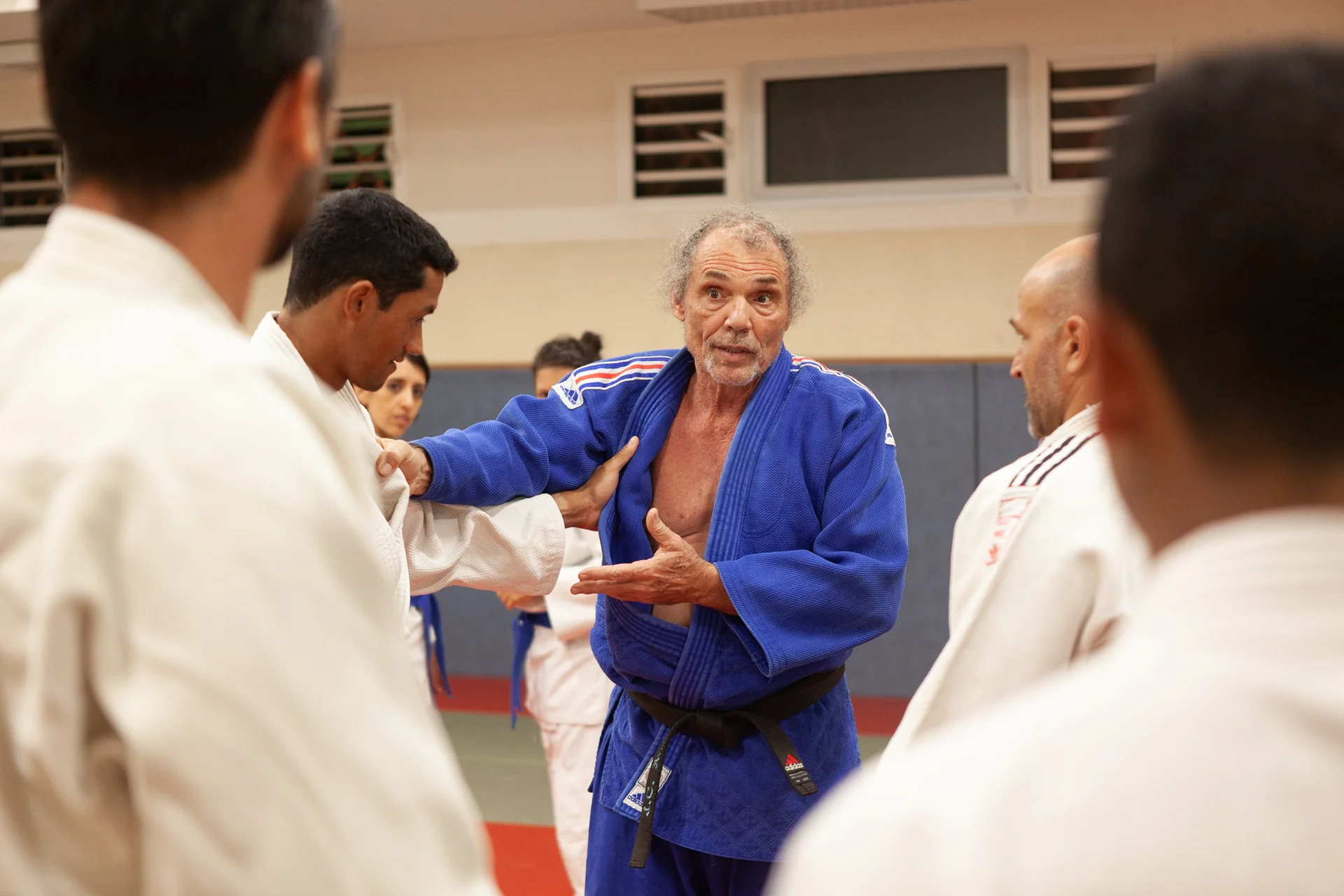 Maître judo enseignant à un groupe, transmission expertise